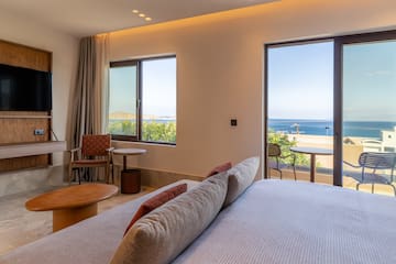 a room with a bed and chairs and a table and chairs