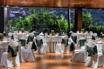 a room with tables and chairs with green bows