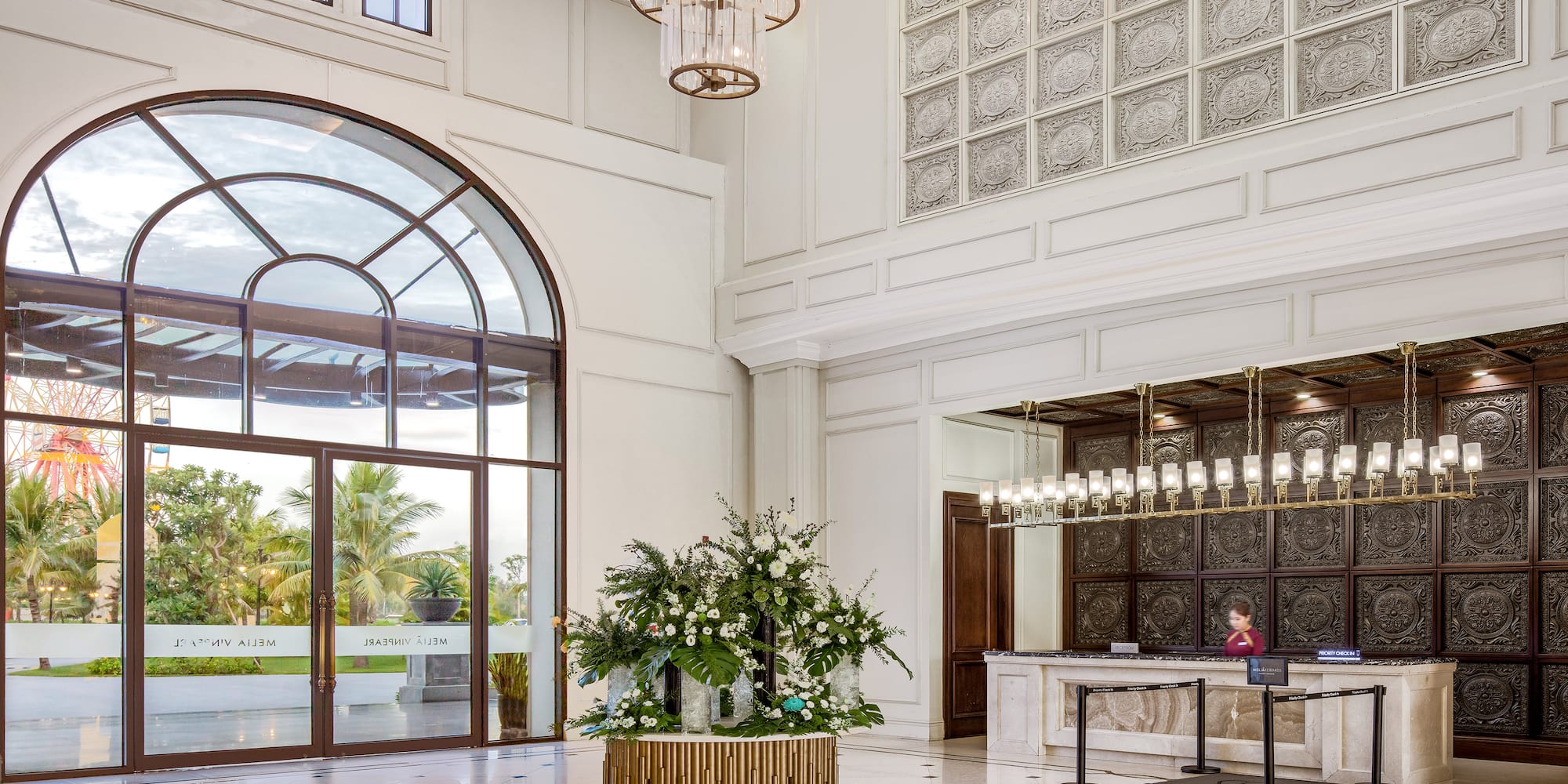 a lobby with a reception desk and chandeliers
