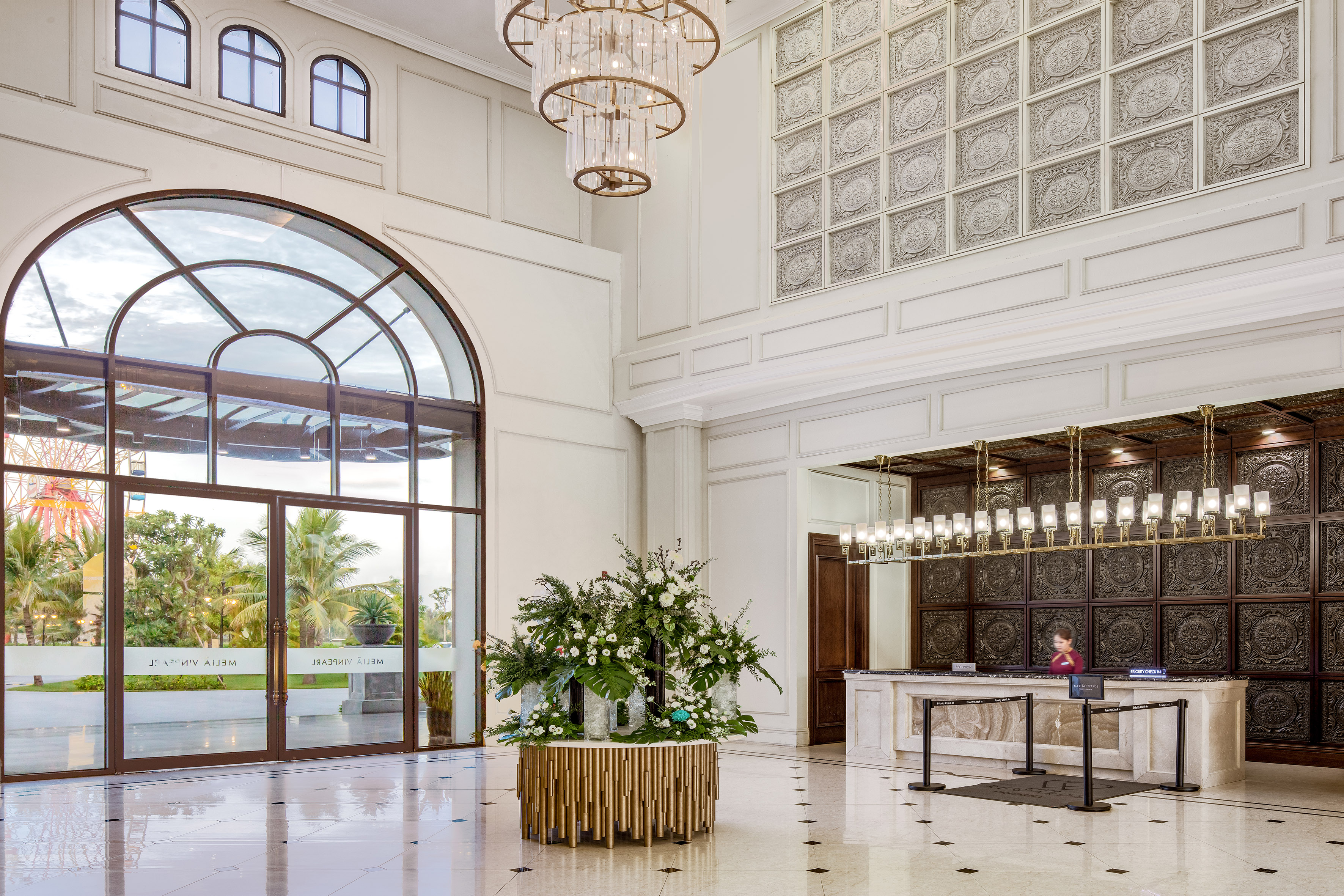 a lobby with a reception desk and chandeliers
