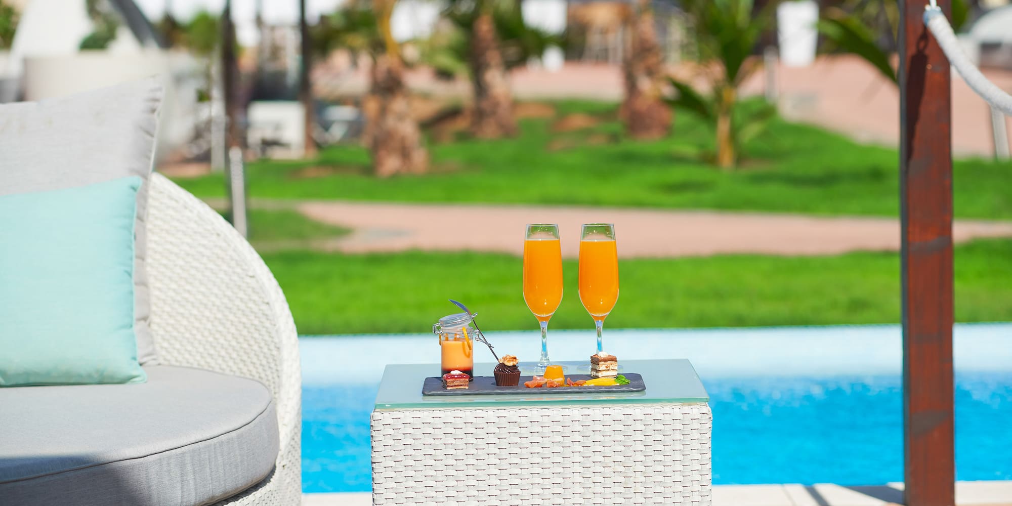 a table with drinks on it by a pool