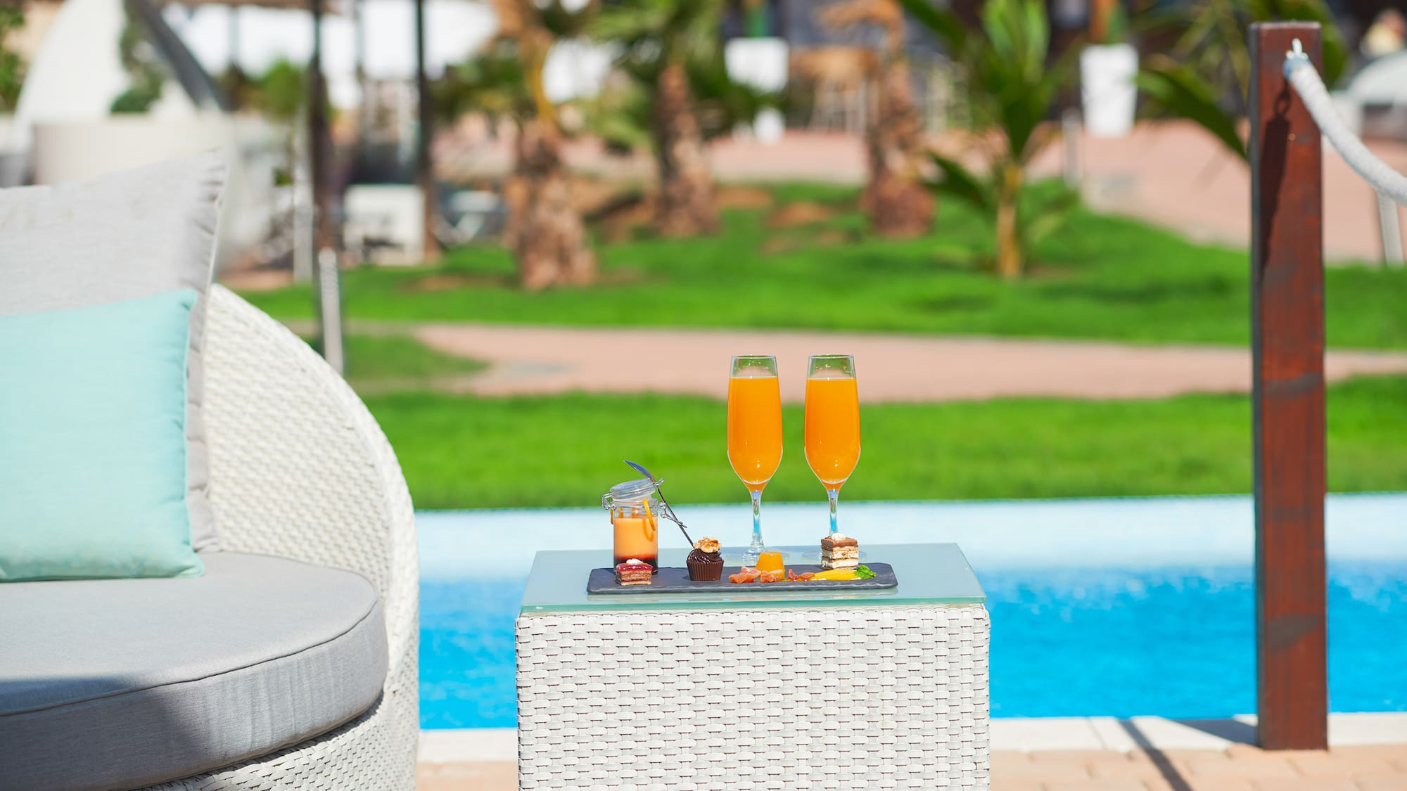 a table with drinks on it by a pool