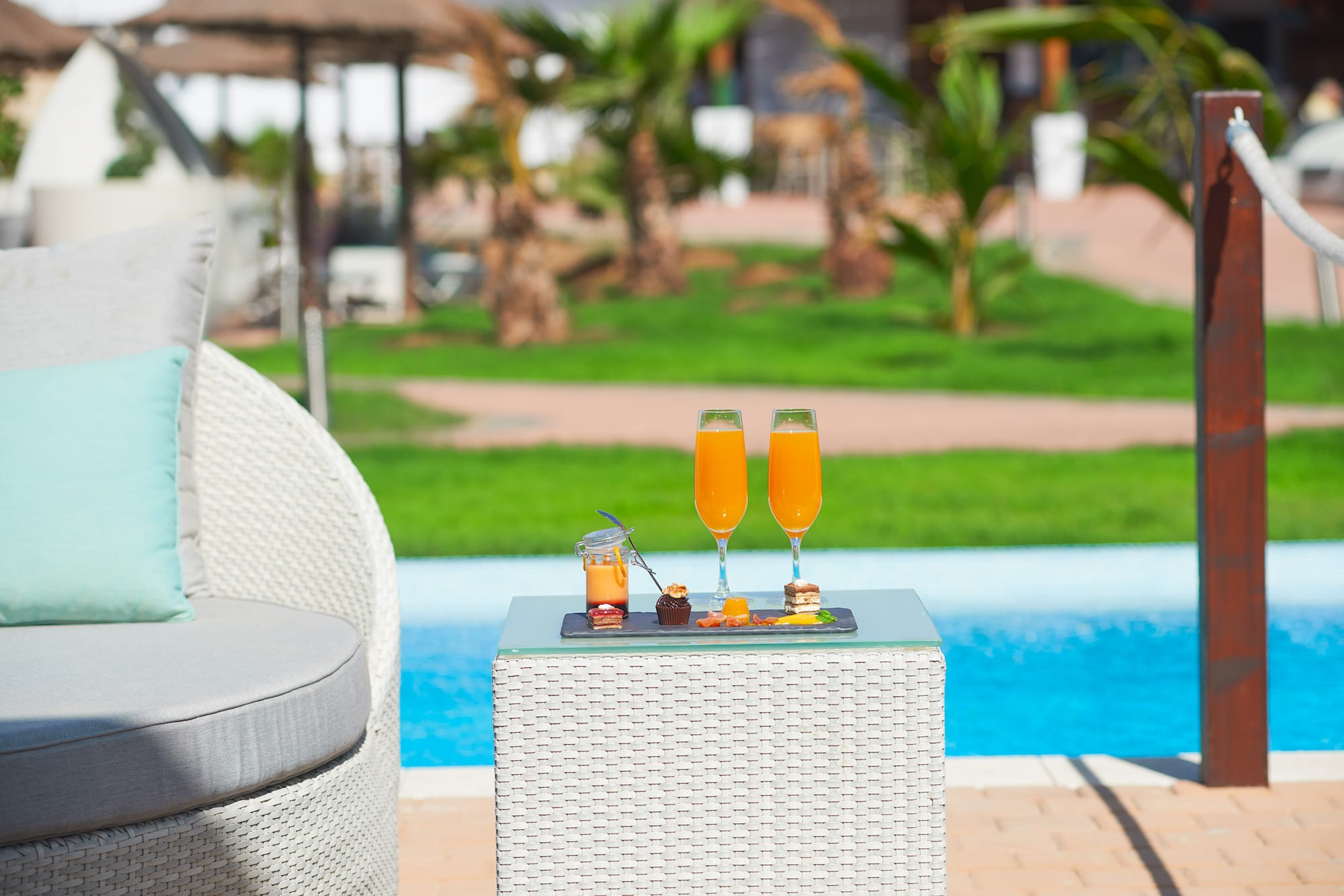 a table with drinks on it by a pool
