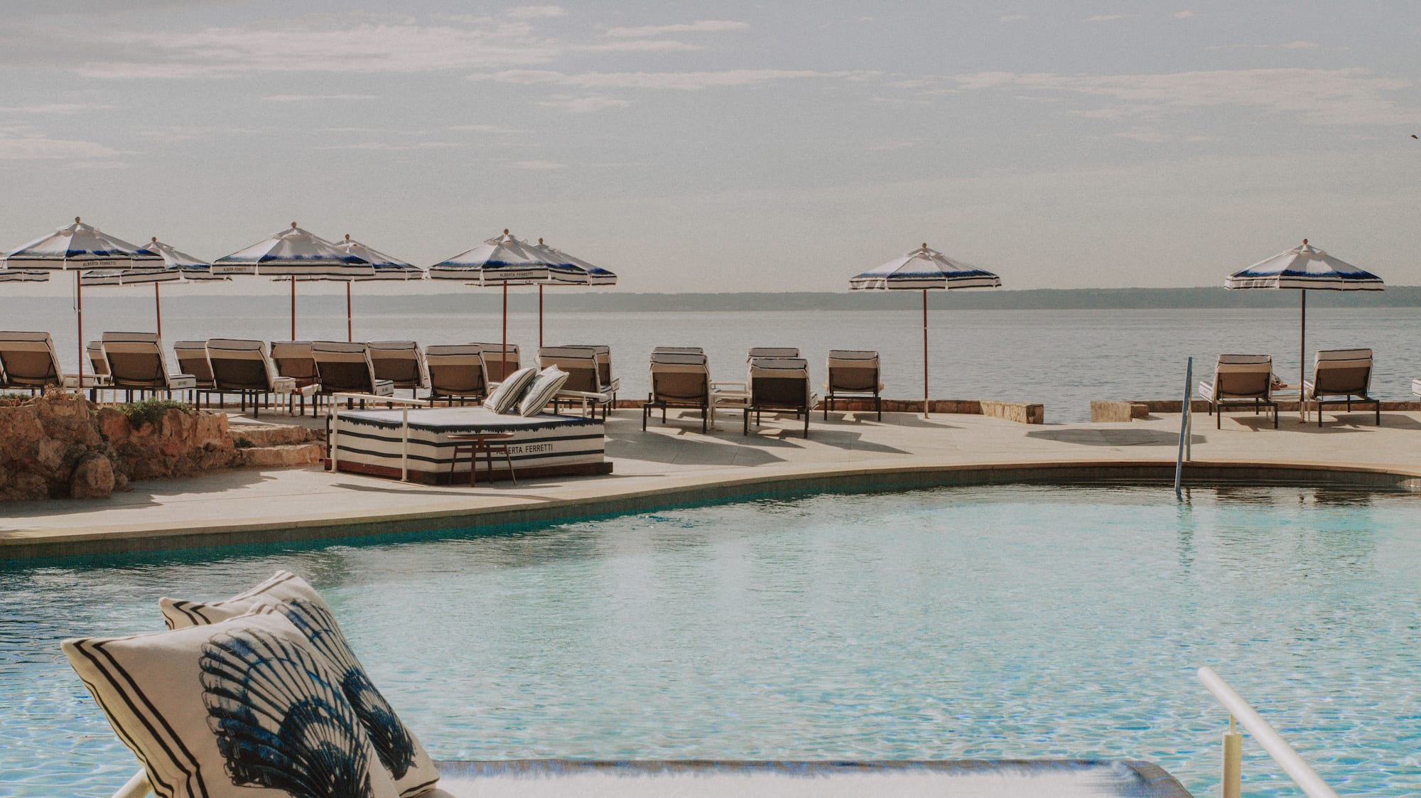 a pool with chairs and umbrellas