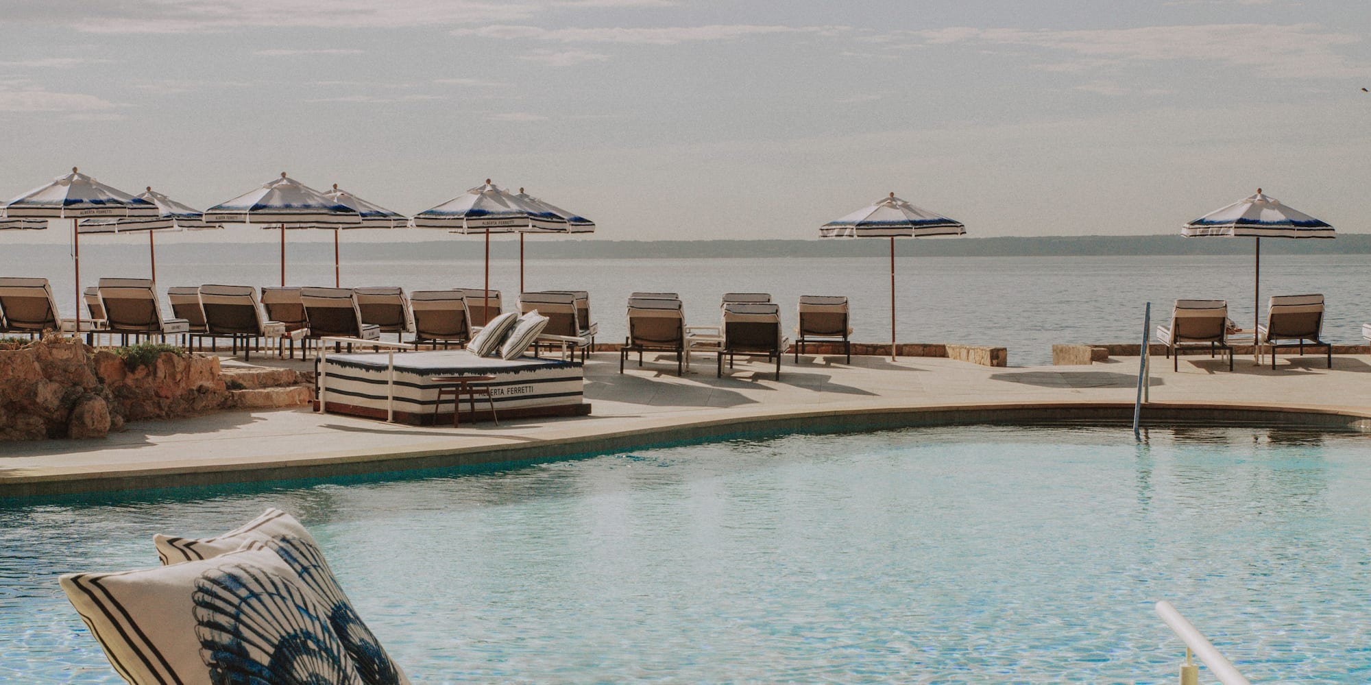 a pool with chairs and umbrellas
