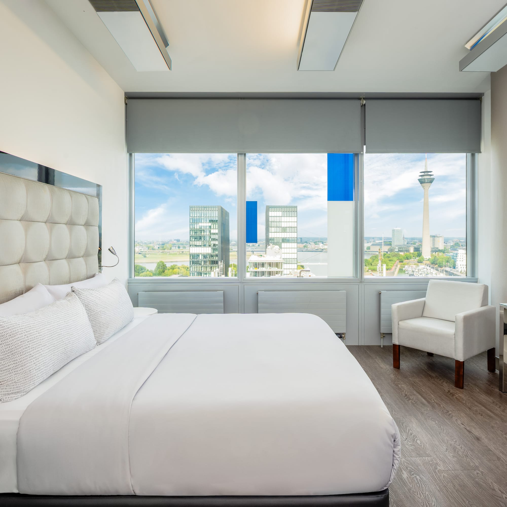 a bedroom with a large bed and chairs