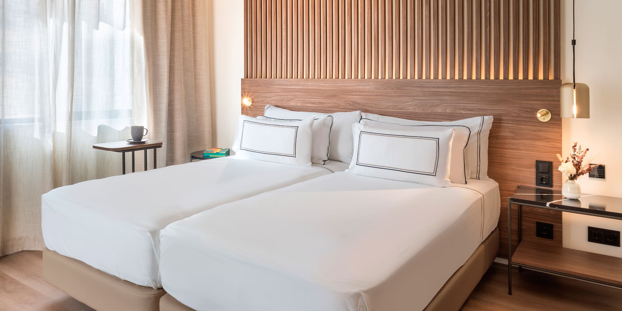 a bed with white sheets and a wood headboard