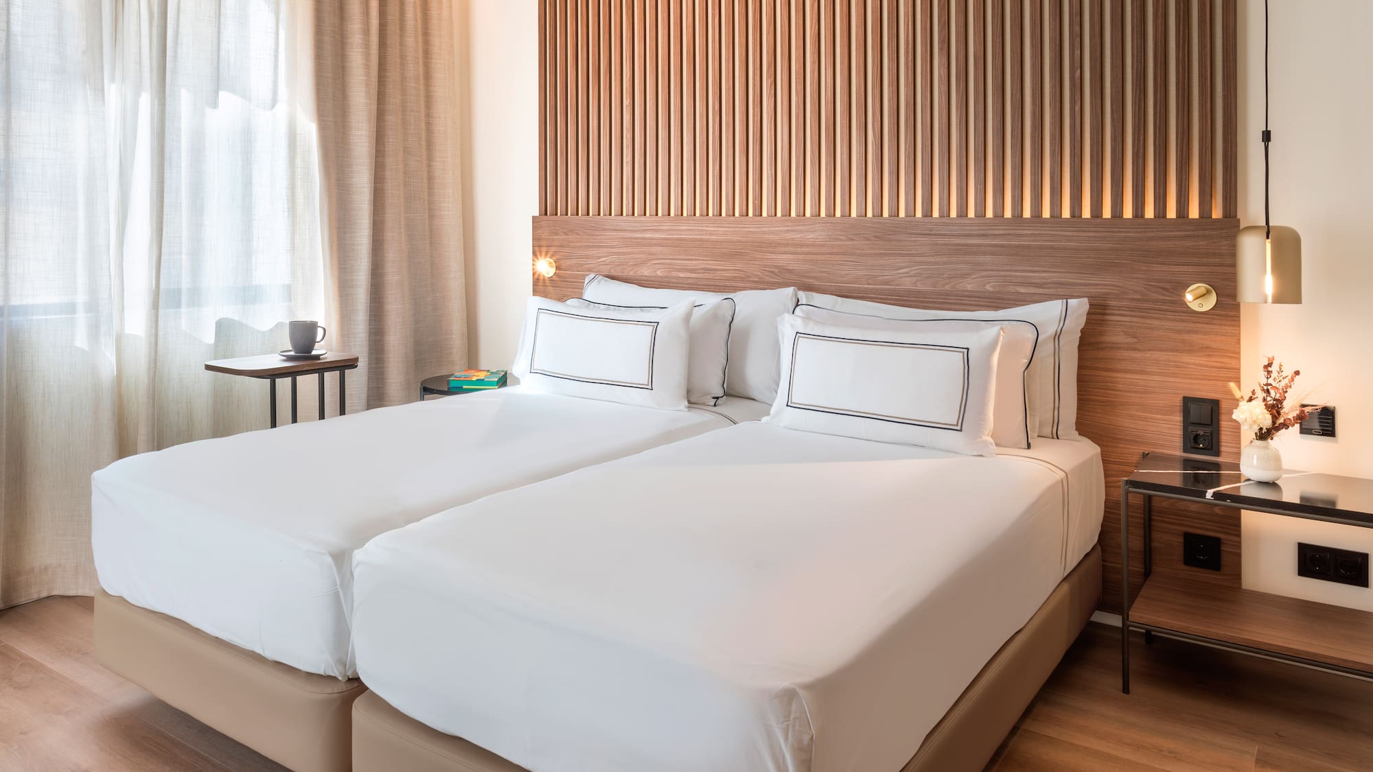 a bed with white sheets and a wood headboard