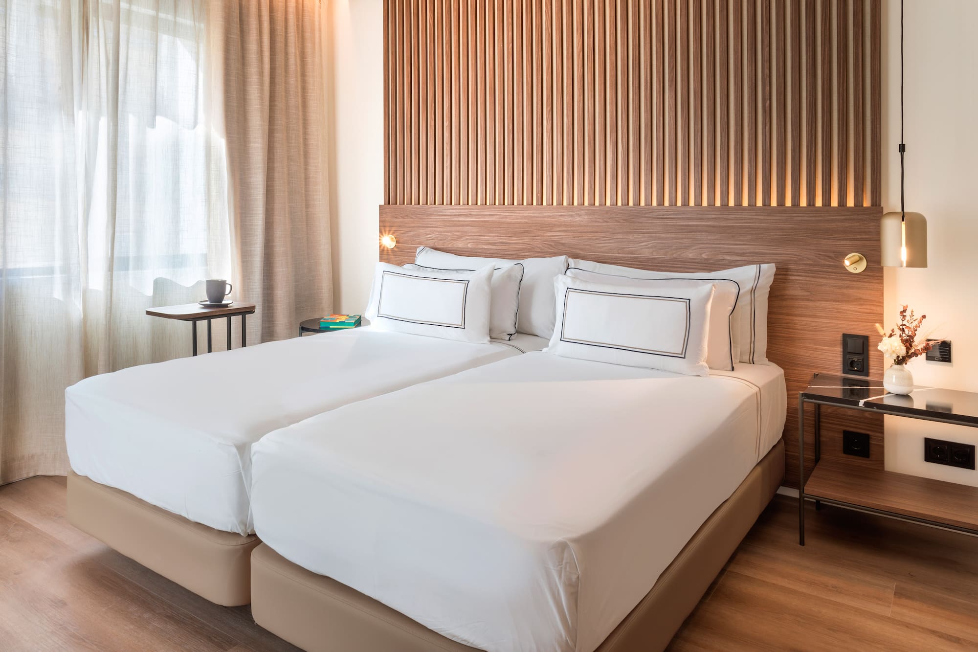 a bed with white sheets and a wood headboard