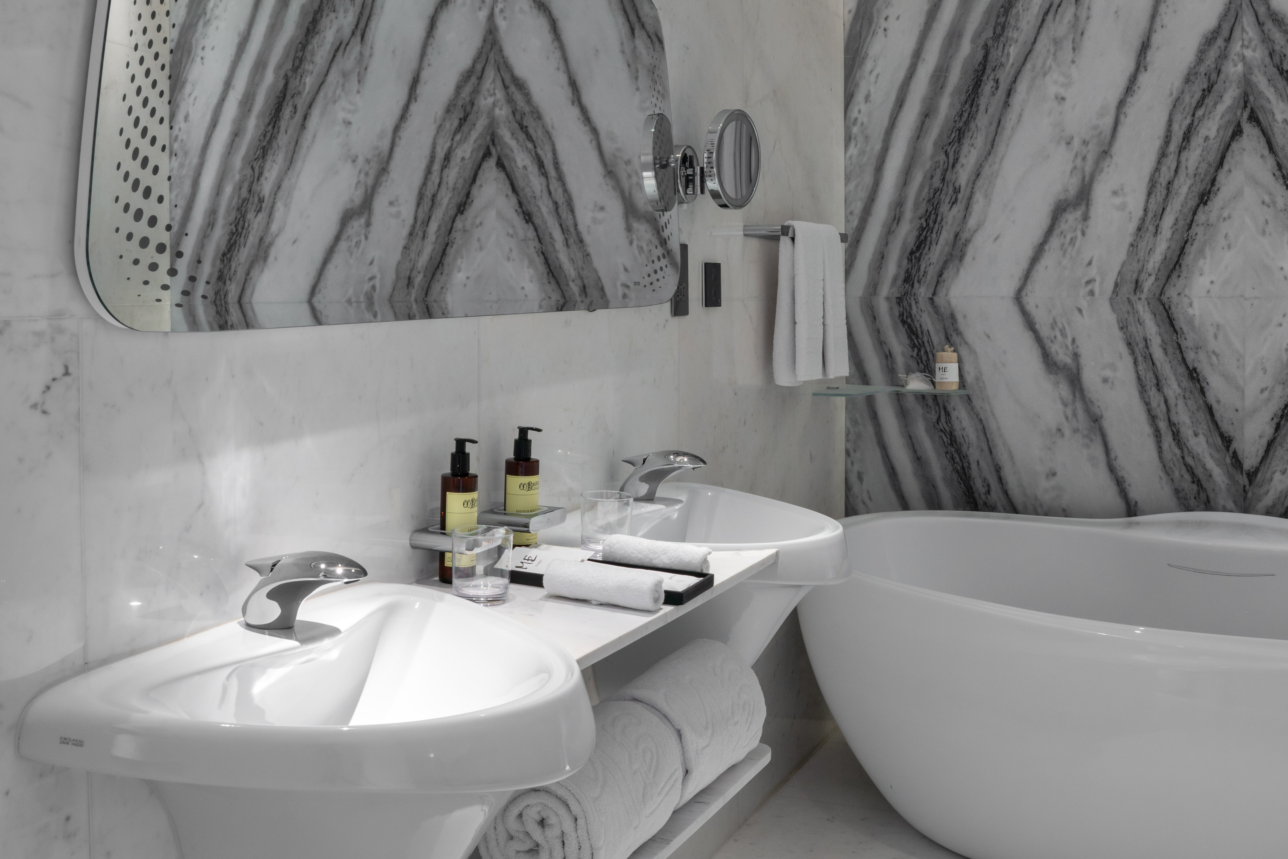 Luxury hotel bathroom with marble walls, twin sinks, and freestanding bathtub. - "1 Bedroom ME Residence منظر المدينة - ME Dubai Residences, دبي
