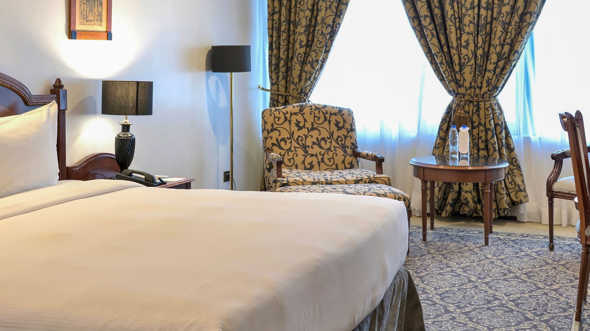 a room with a bed and chairs and a table