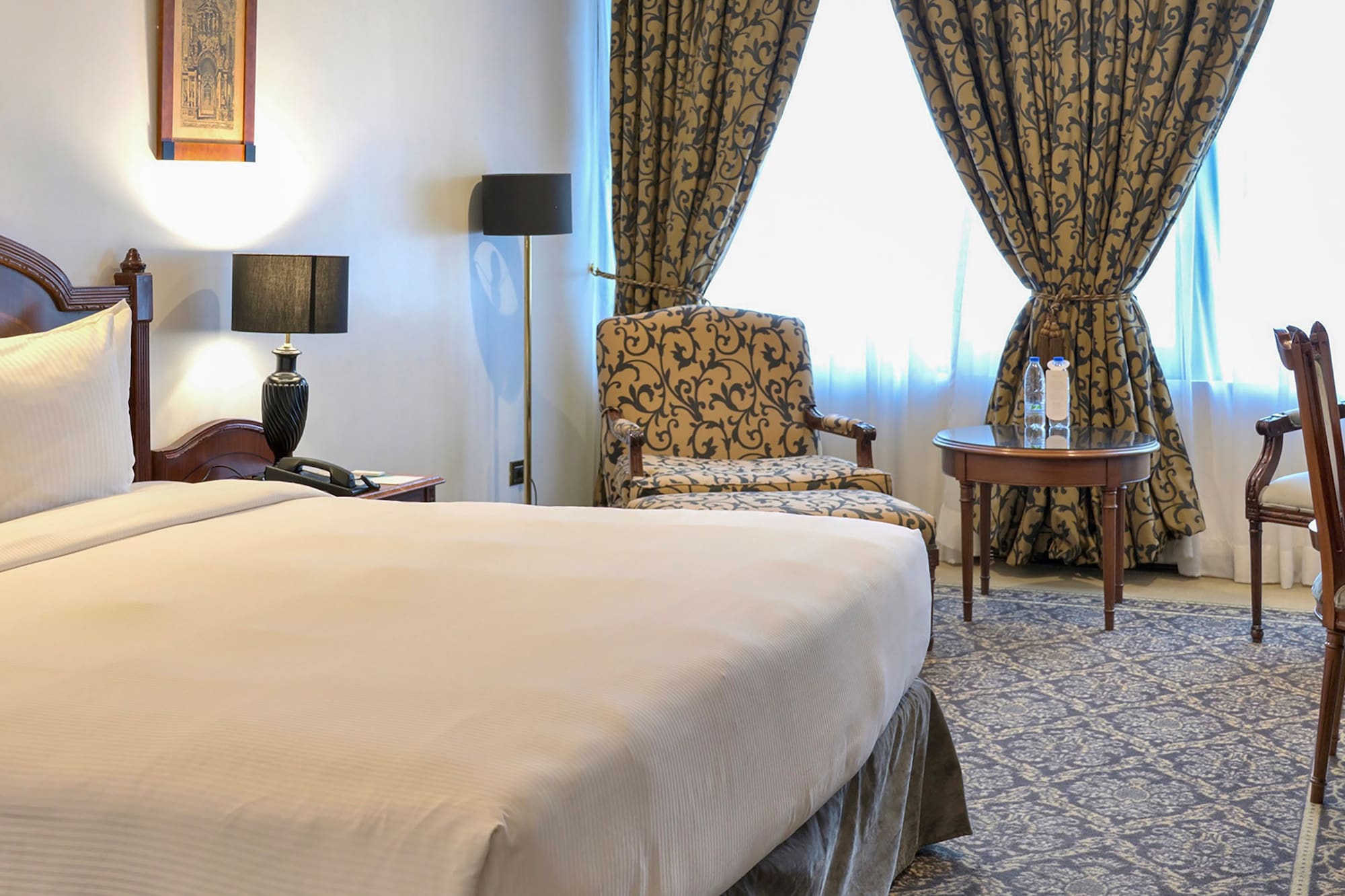 a room with a bed and chairs and a table