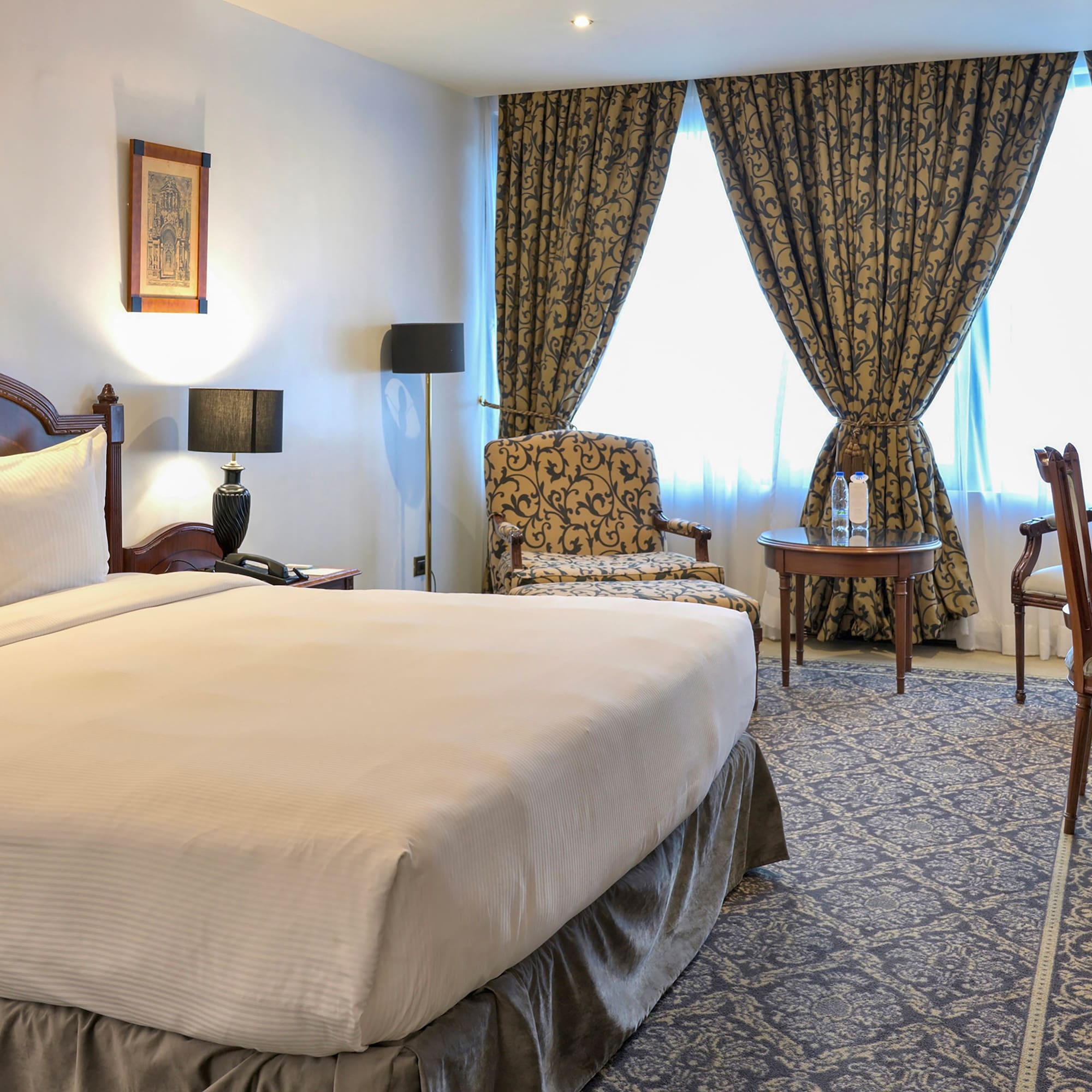 a room with a bed and chairs and a table