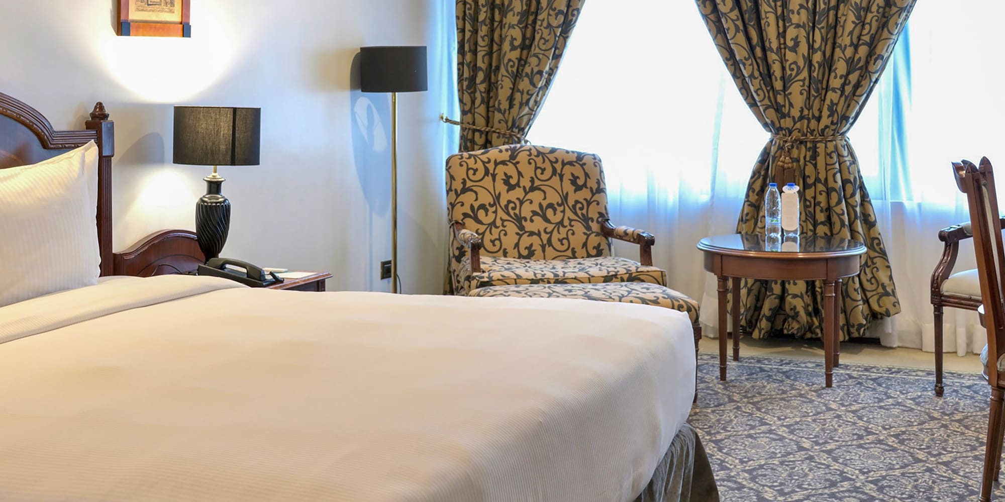 a room with a bed and chairs and a table