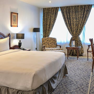 a room with a bed and chairs and a table
