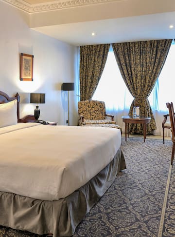 a room with a bed and chairs and a table