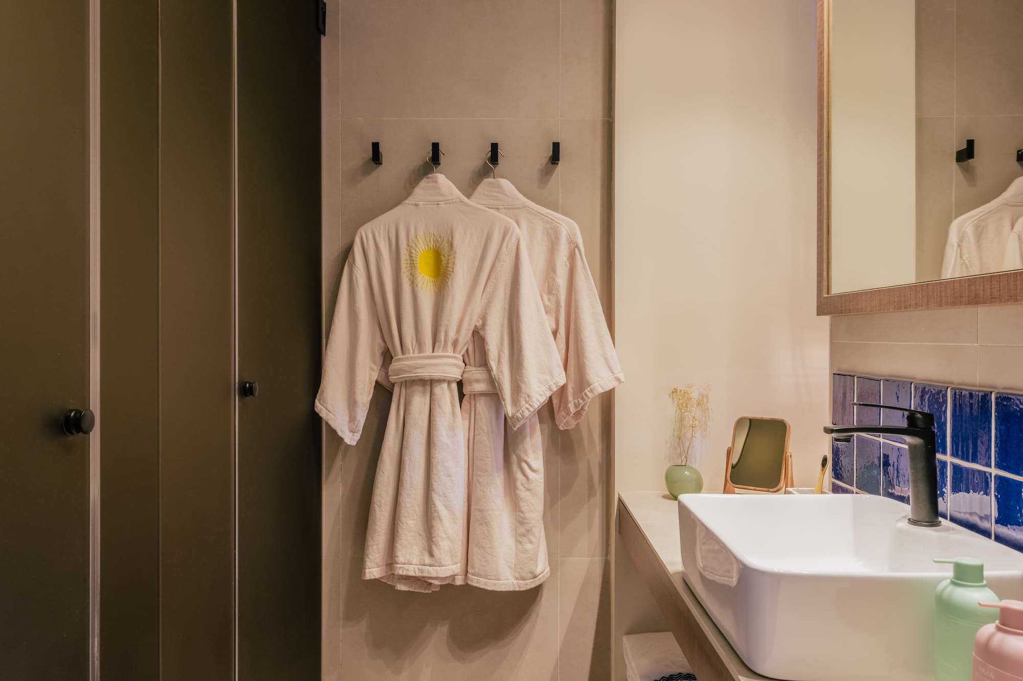 a bathroom with a bathrobe and sink