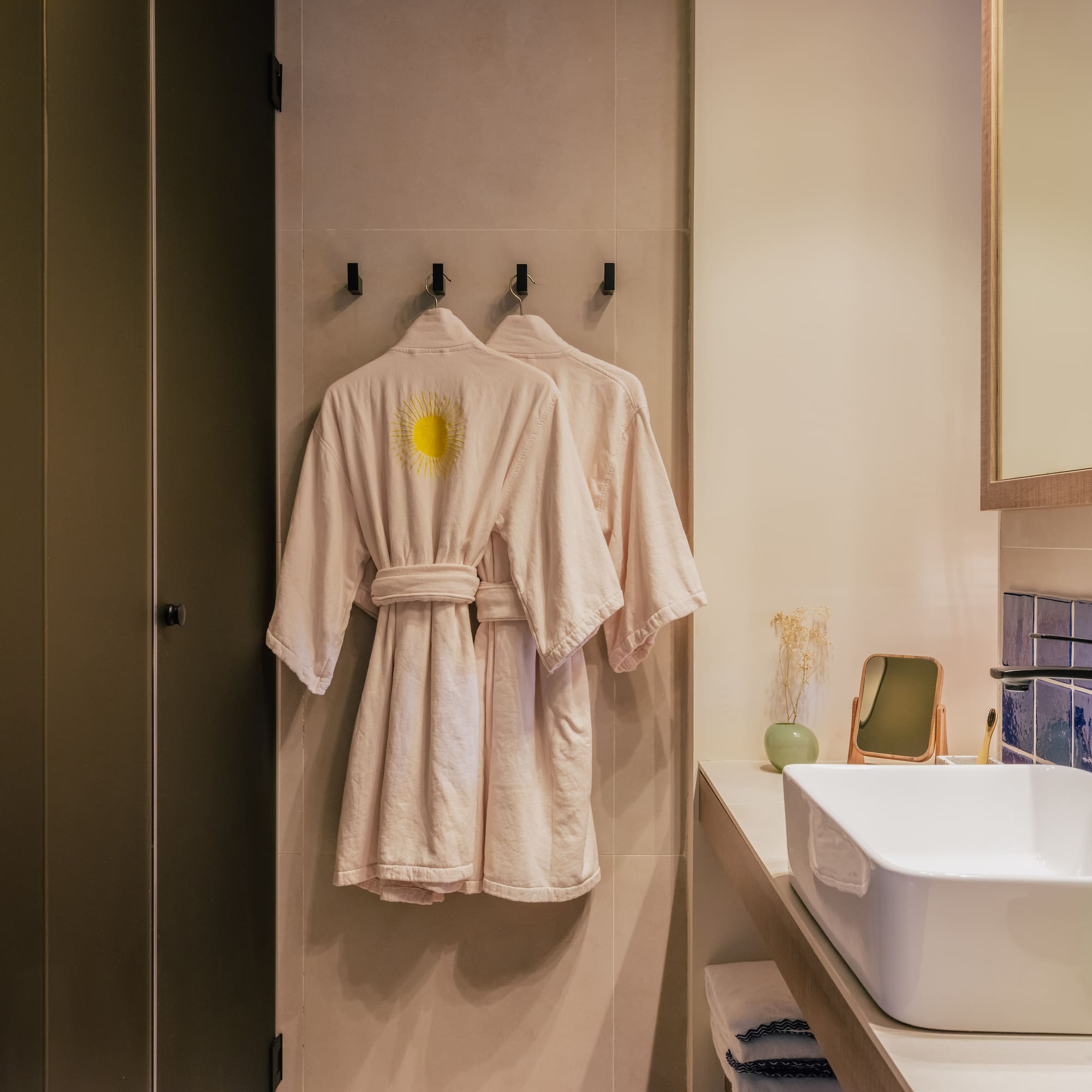 a bathroom with a bathrobe and sink
