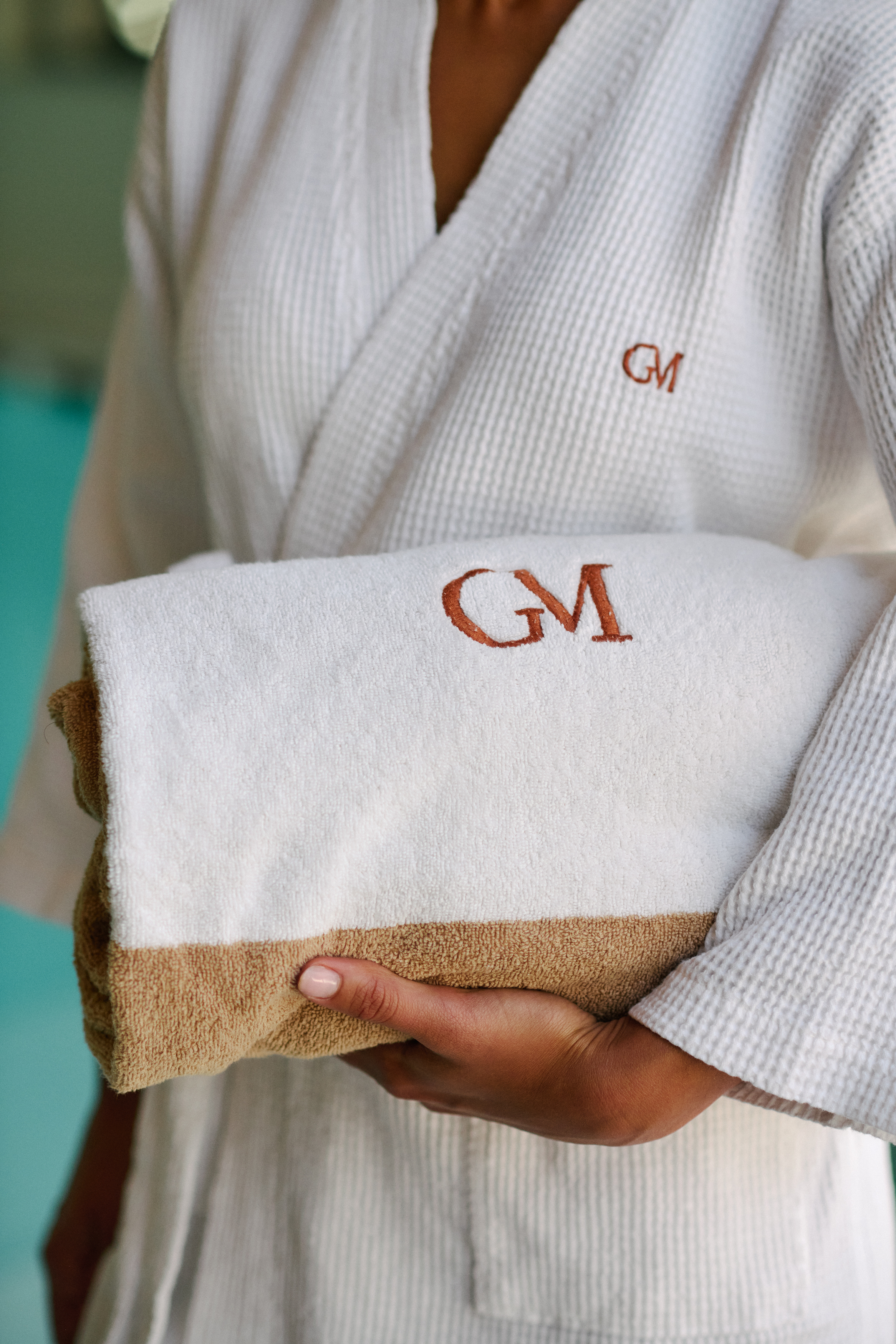 White waffle bathrobe, GM monogrammed towel with tan trim, for spa or hotel.