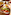 Hand dipping chip into loaded nachos with guacamole and sour cream, outdoor fast food.