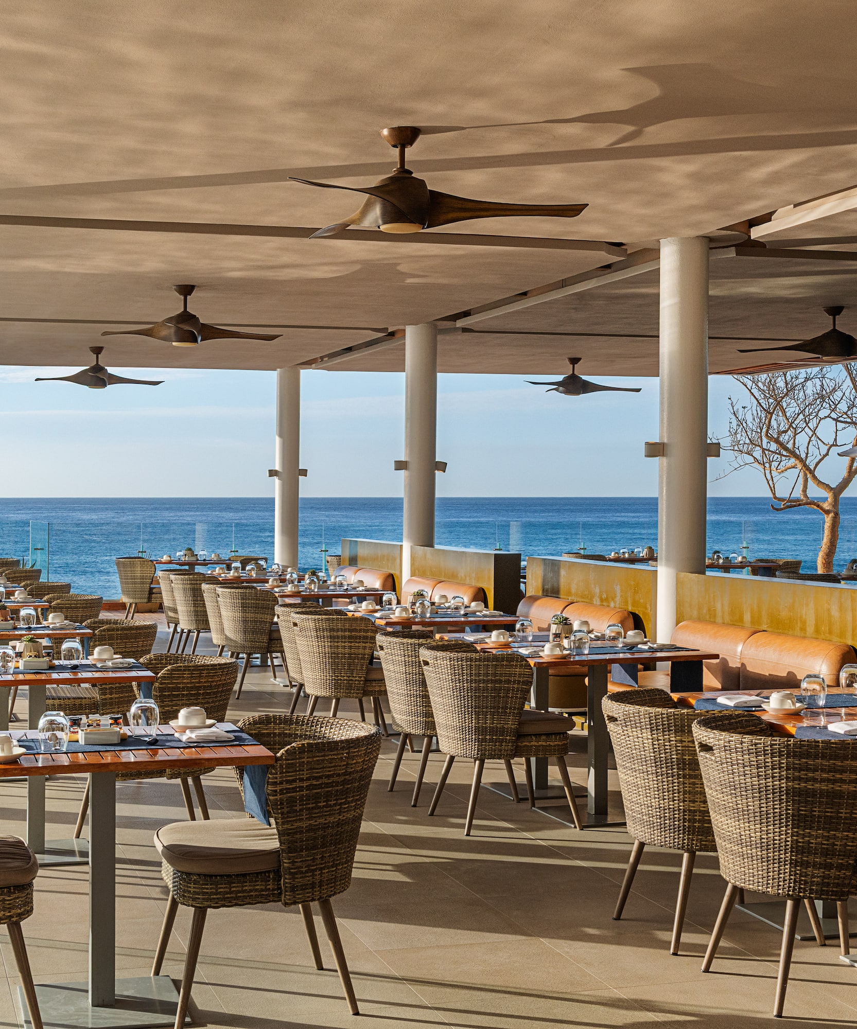 a restaurant with tables and chairs and a large body of water