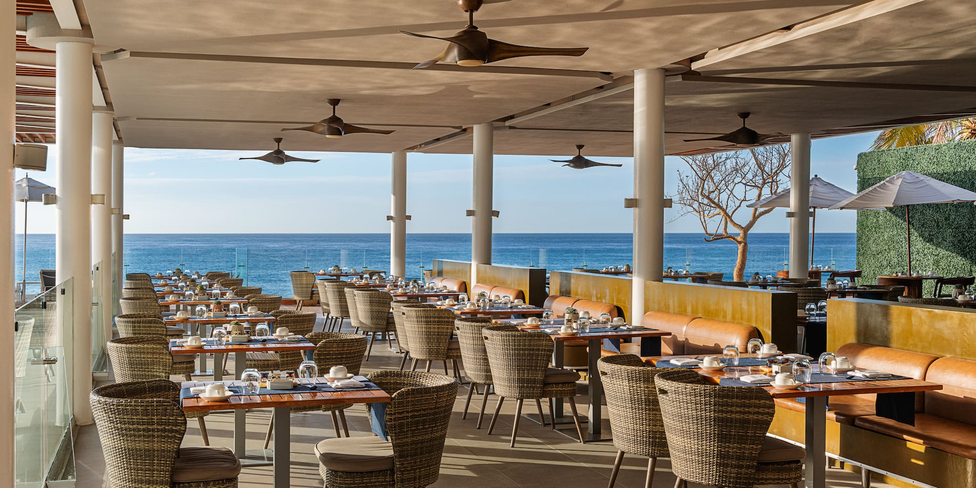 a restaurant with tables and chairs and a large body of water