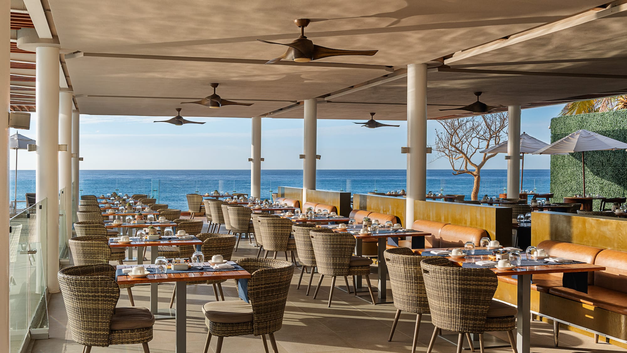 a restaurant with tables and chairs and a large body of water