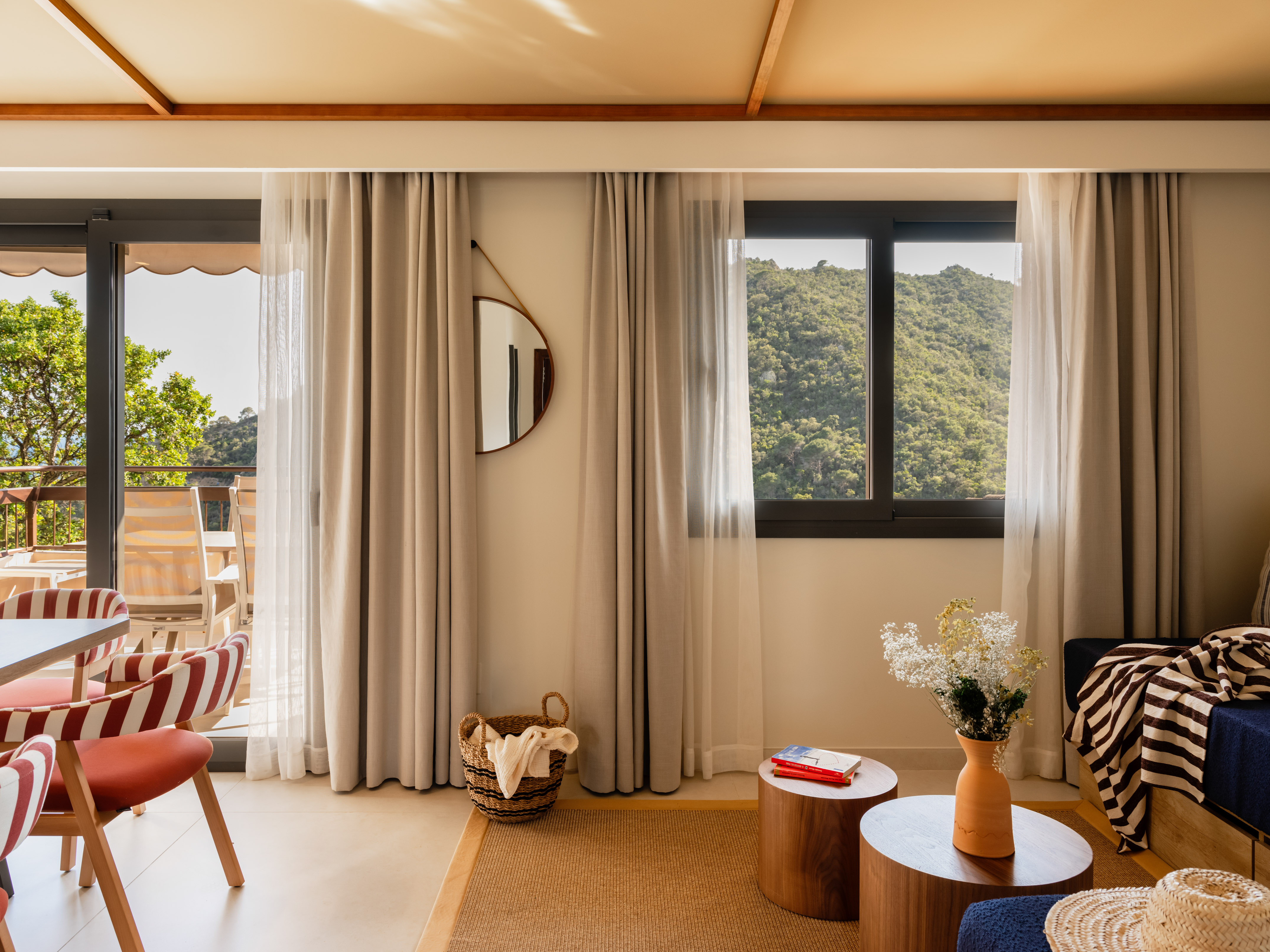 Hotel suite living room with mountain view, balcony, and modern decor.
