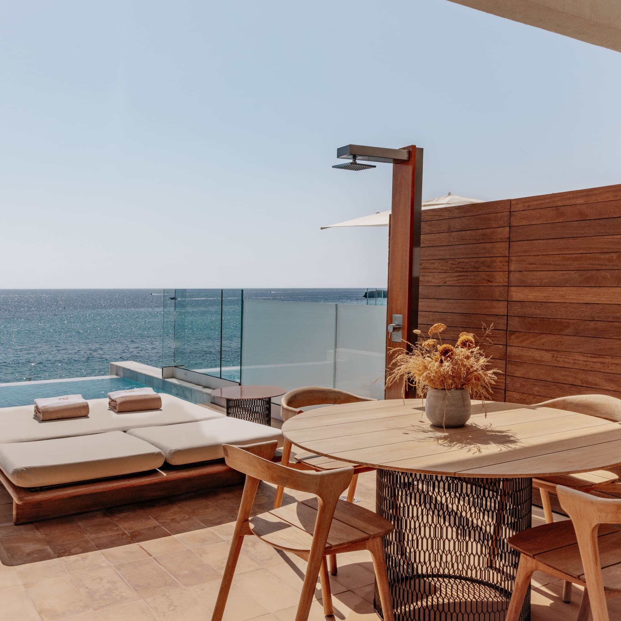 a table and chairs on a patio overlooking the ocean