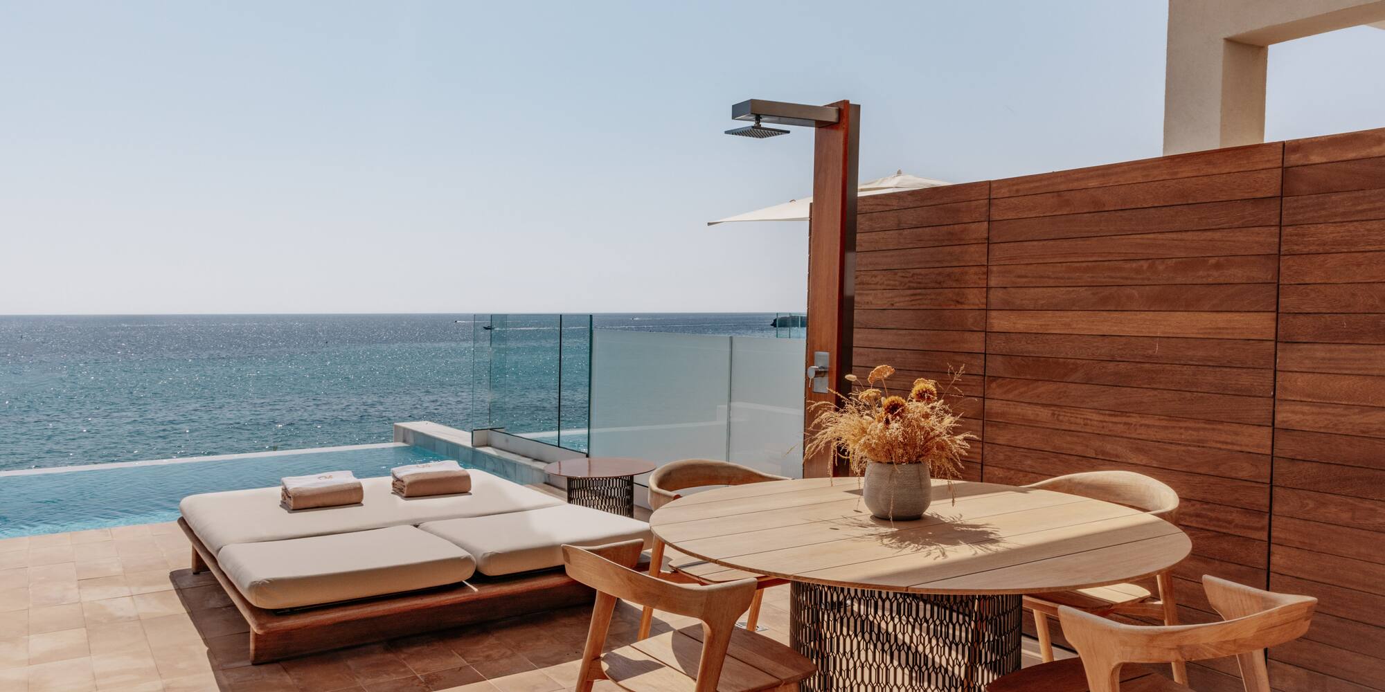 a table and chairs on a patio overlooking the ocean