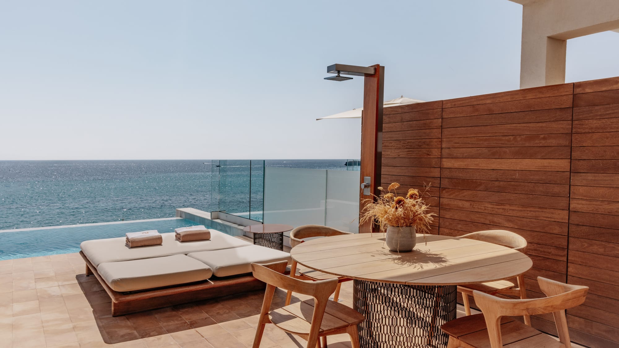 a table and chairs on a patio overlooking the ocean