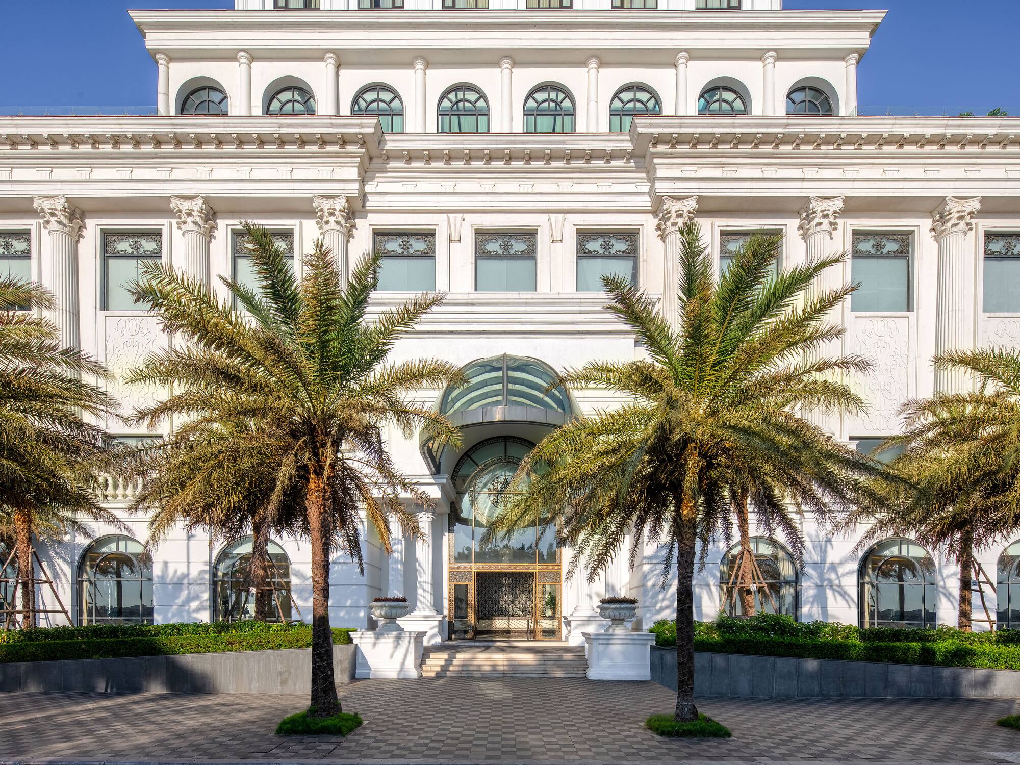 a white building with palm trees