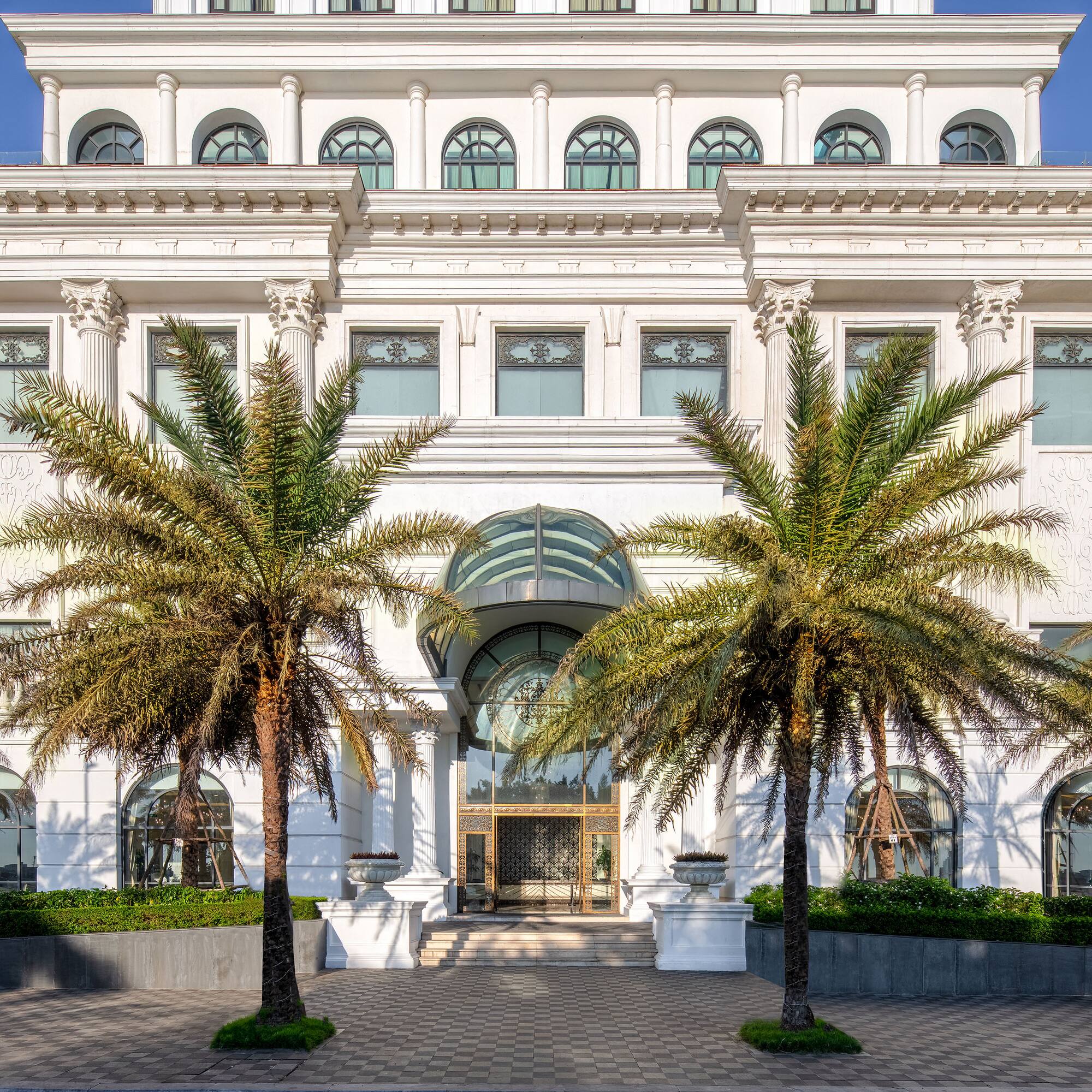 a white building with palm trees