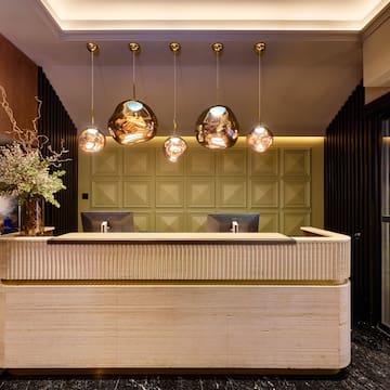 a reception desk with lights from the ceiling