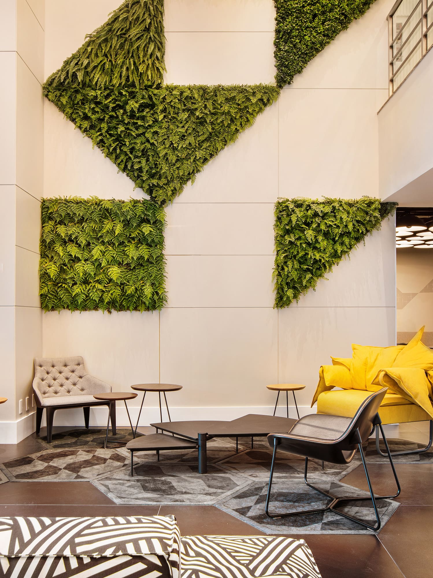 a room with a plant wall and chairs