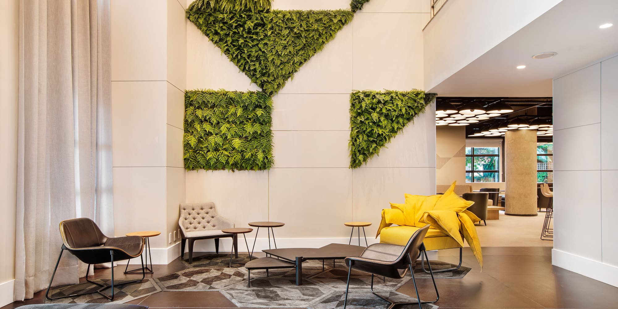 a room with a plant wall and chairs