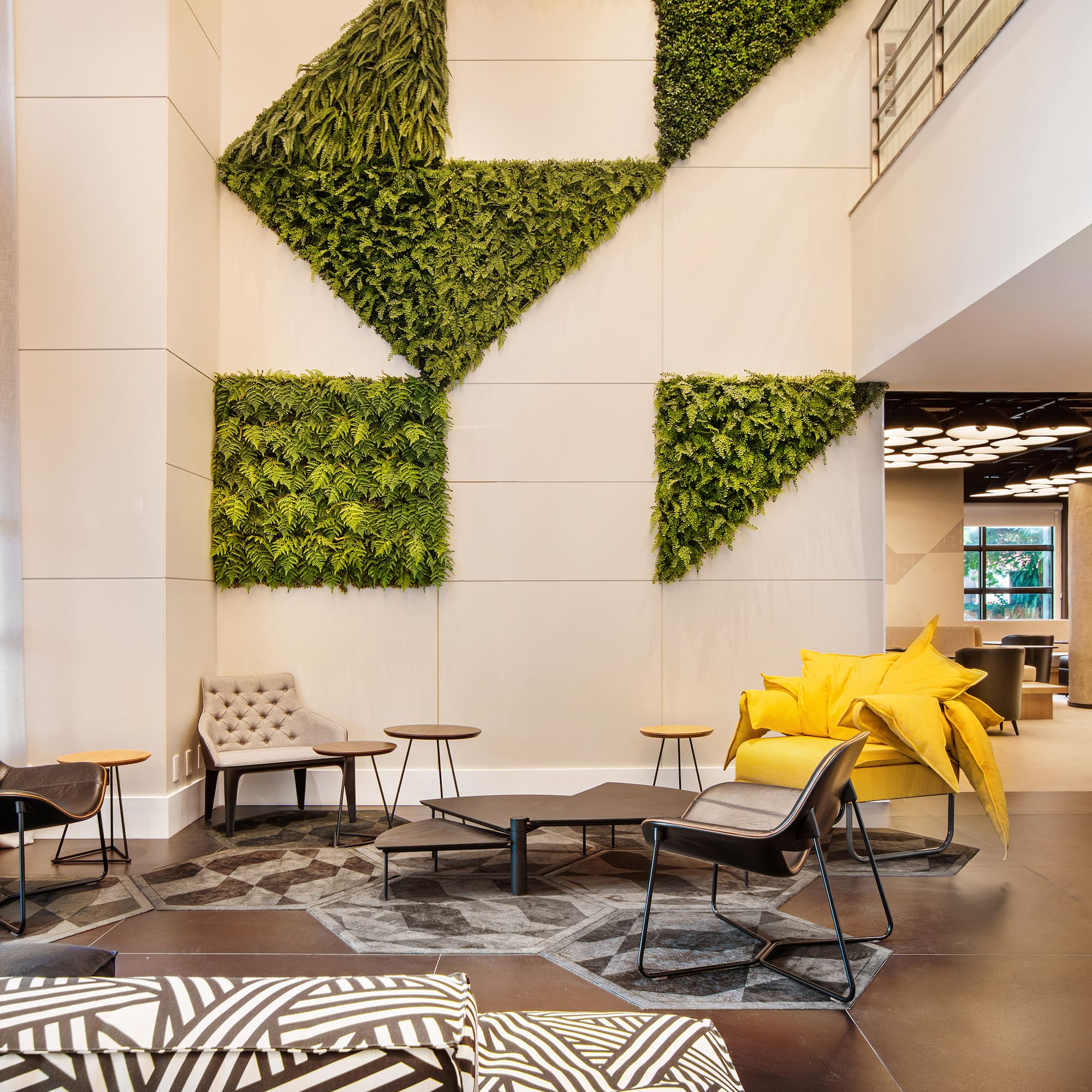 a room with a plant wall and chairs