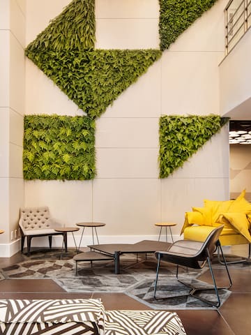 a room with a plant wall and chairs