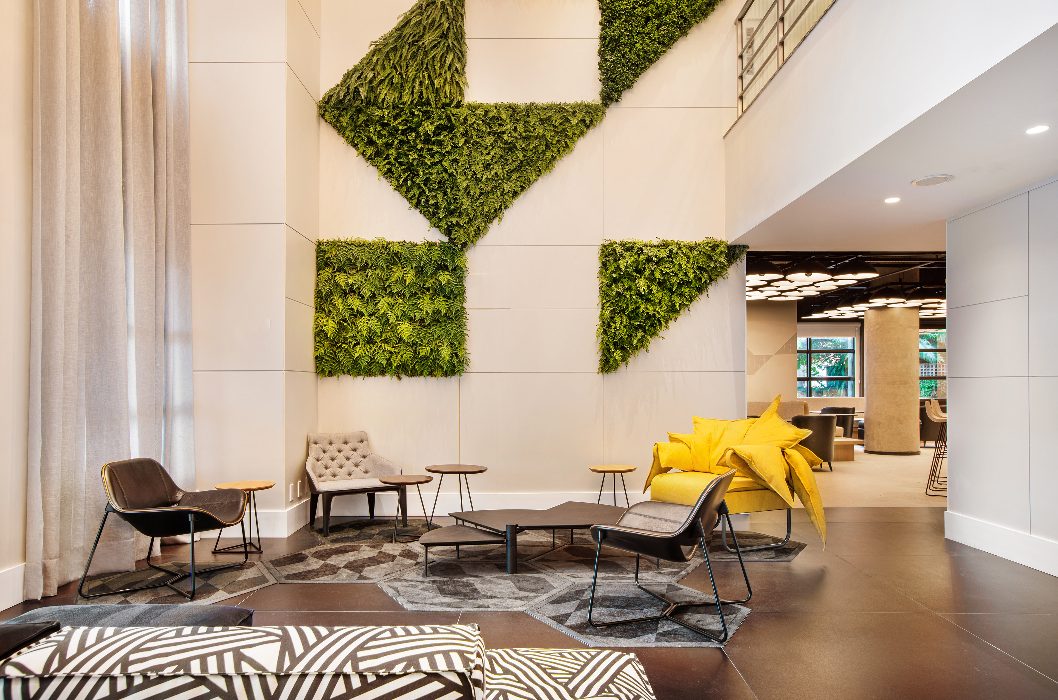 Lounge area with geometric green living wall and modern furniture.