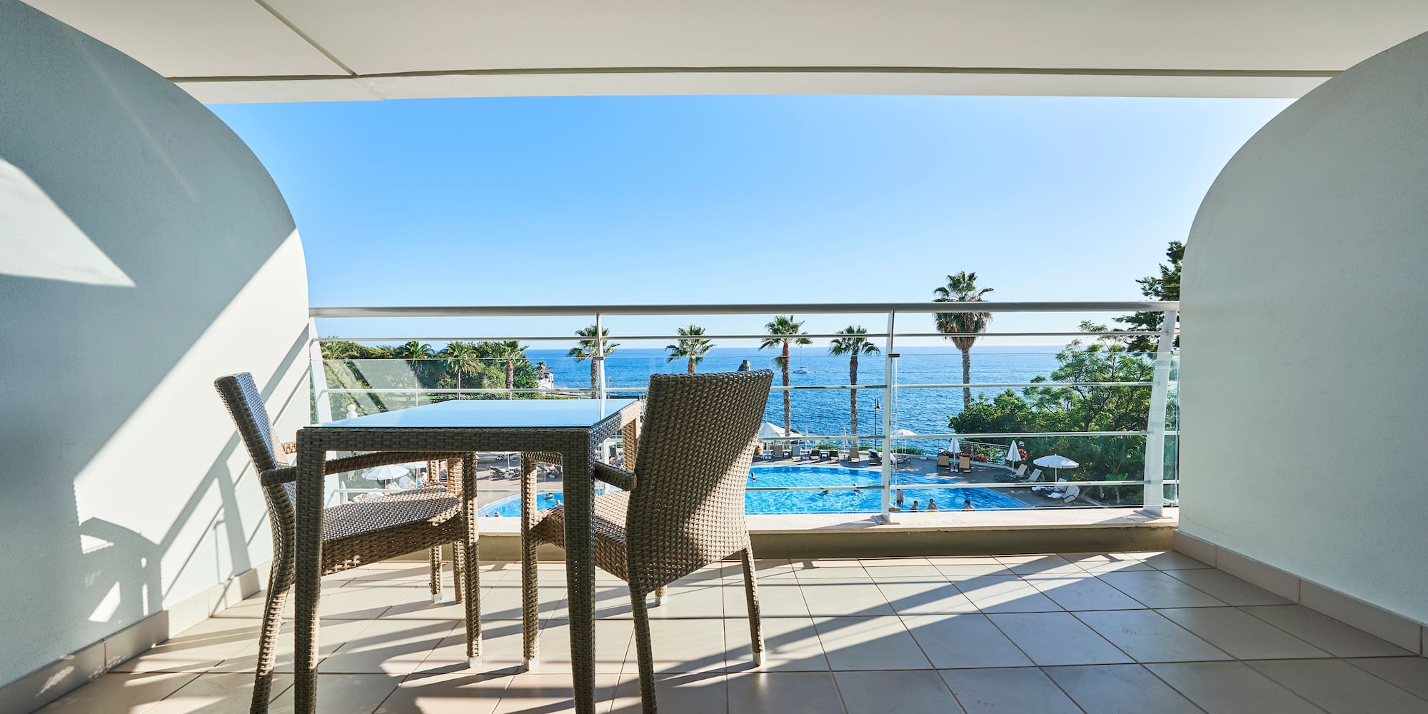 a table and chairs on a balcony overlooking a pool