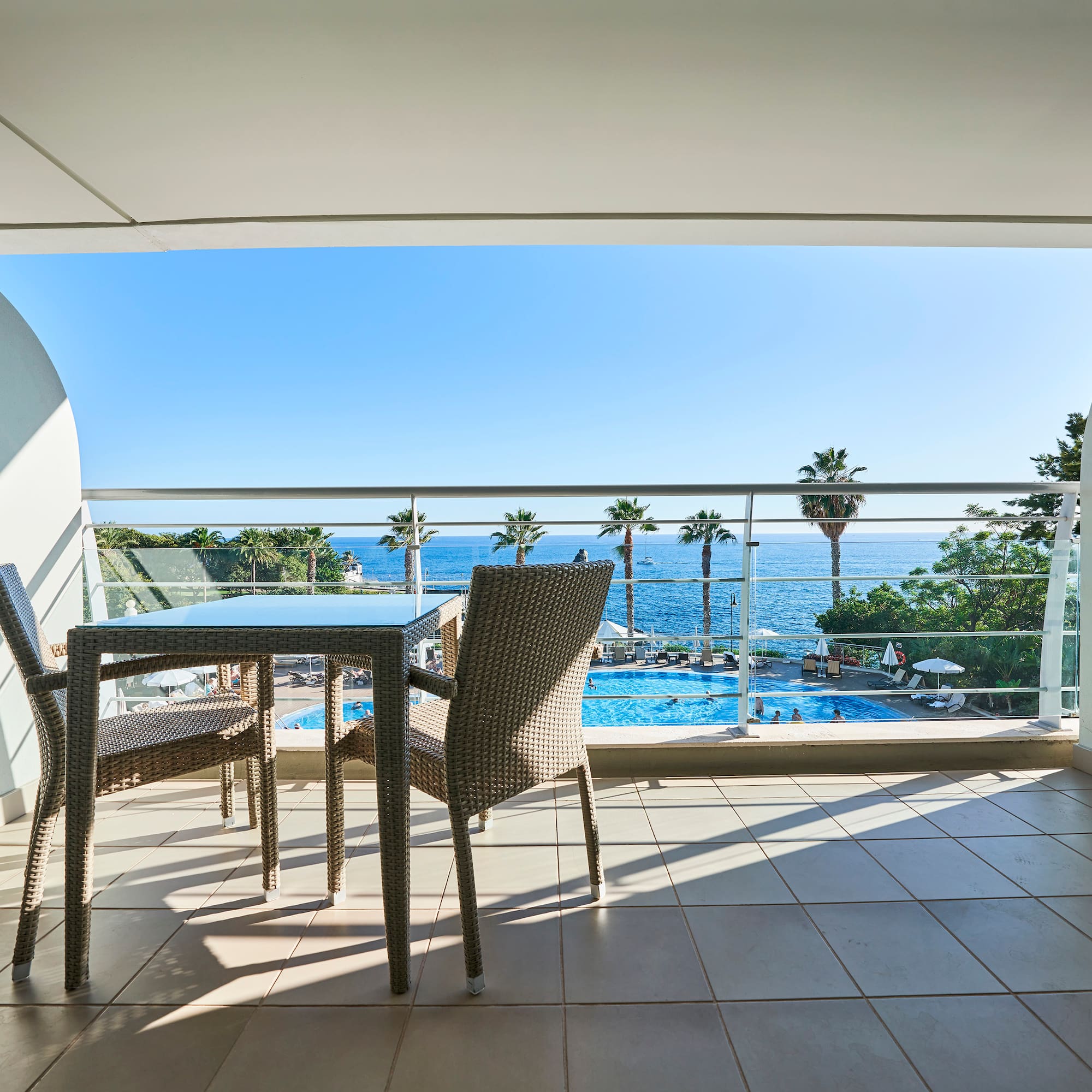 a table and chairs on a balcony overlooking a pool