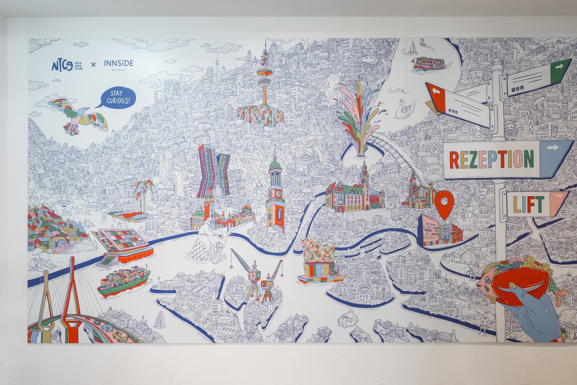 Whimsical hotel city map mural showing reception and lift directions.
