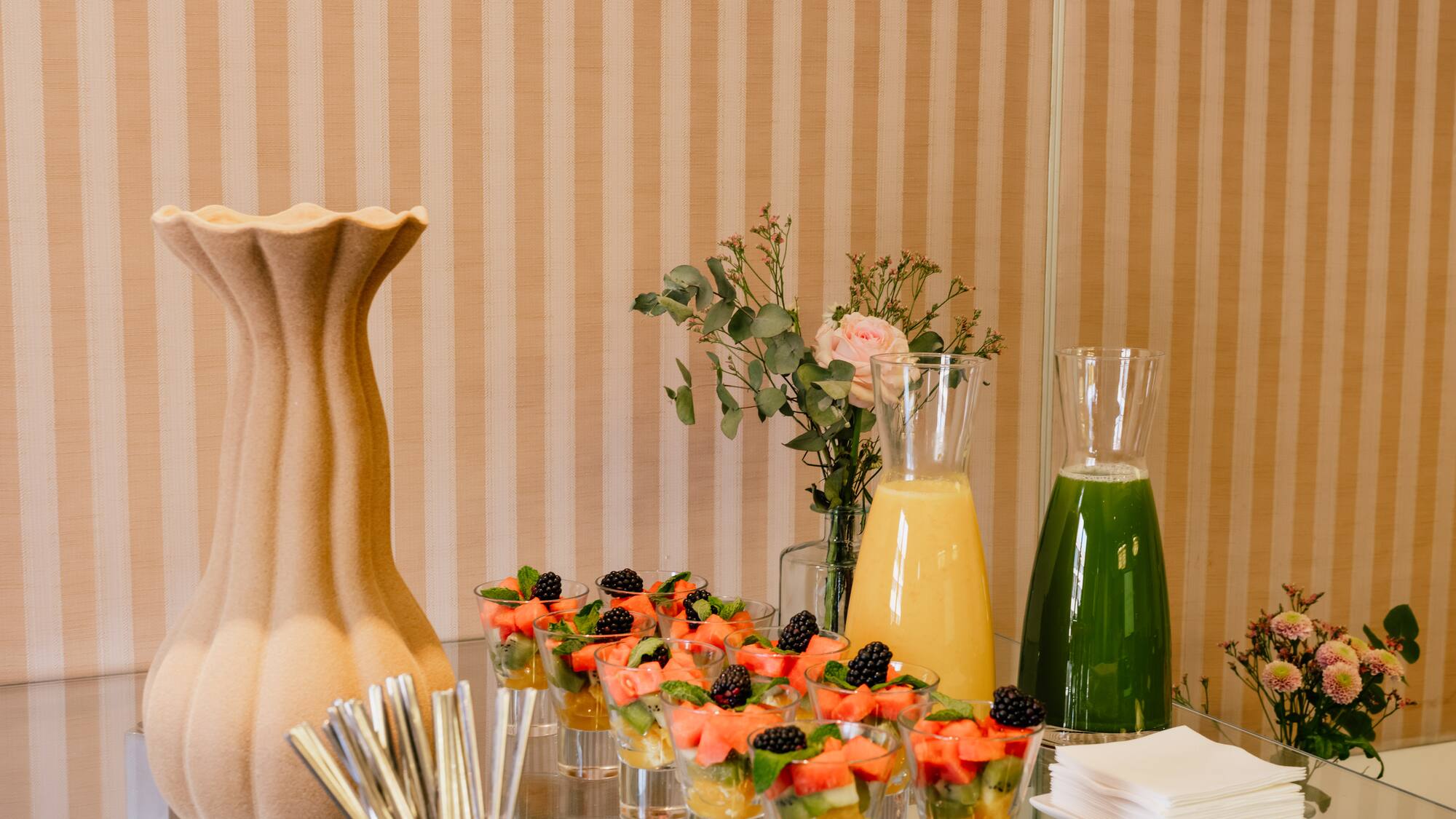 a table with glasses of fruit and juice