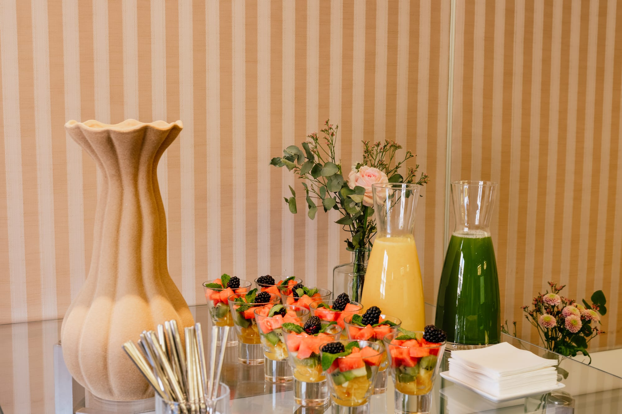 a table with glasses of fruit and juice