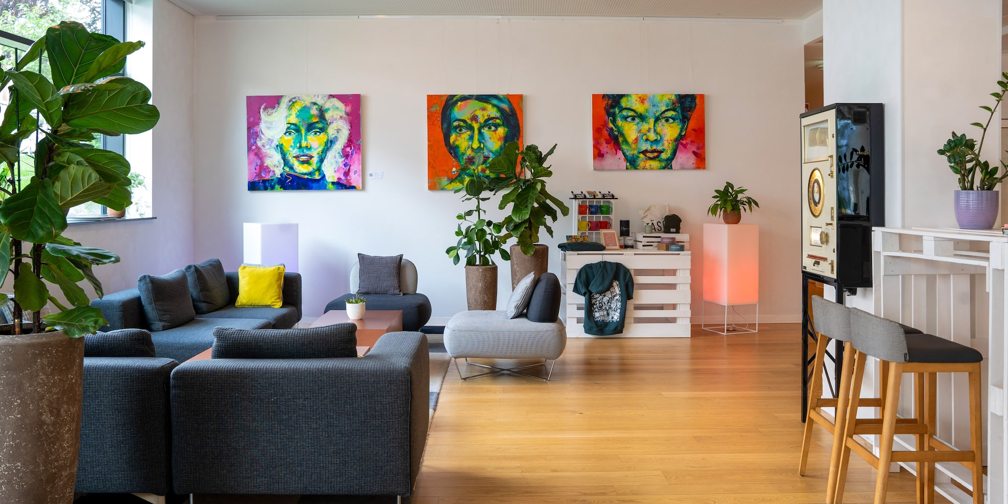 a living room with couches and paintings on the wall