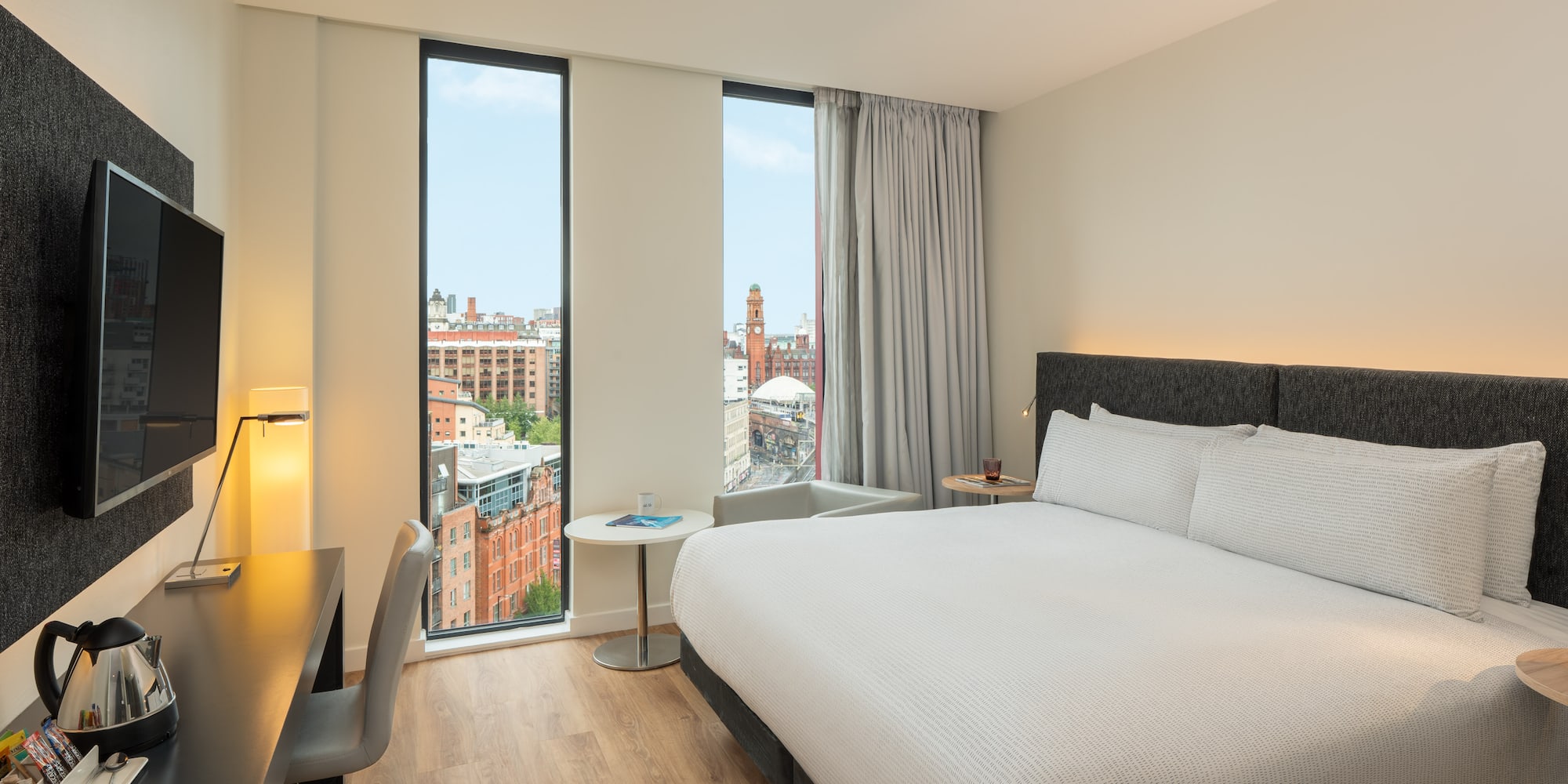 a room with a bed and a desk and a window