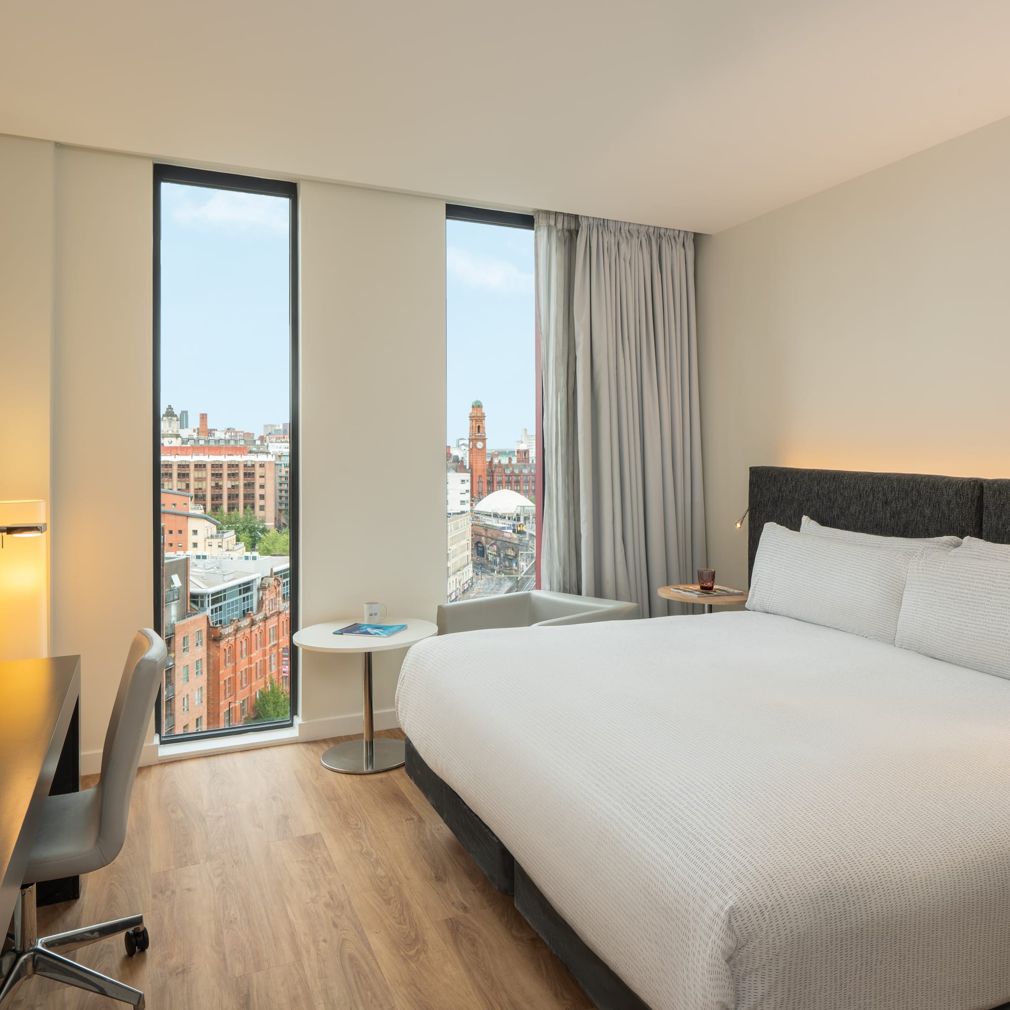 a room with a bed and a desk and a window