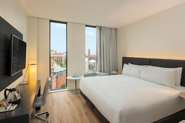 a room with a bed and a desk and a window