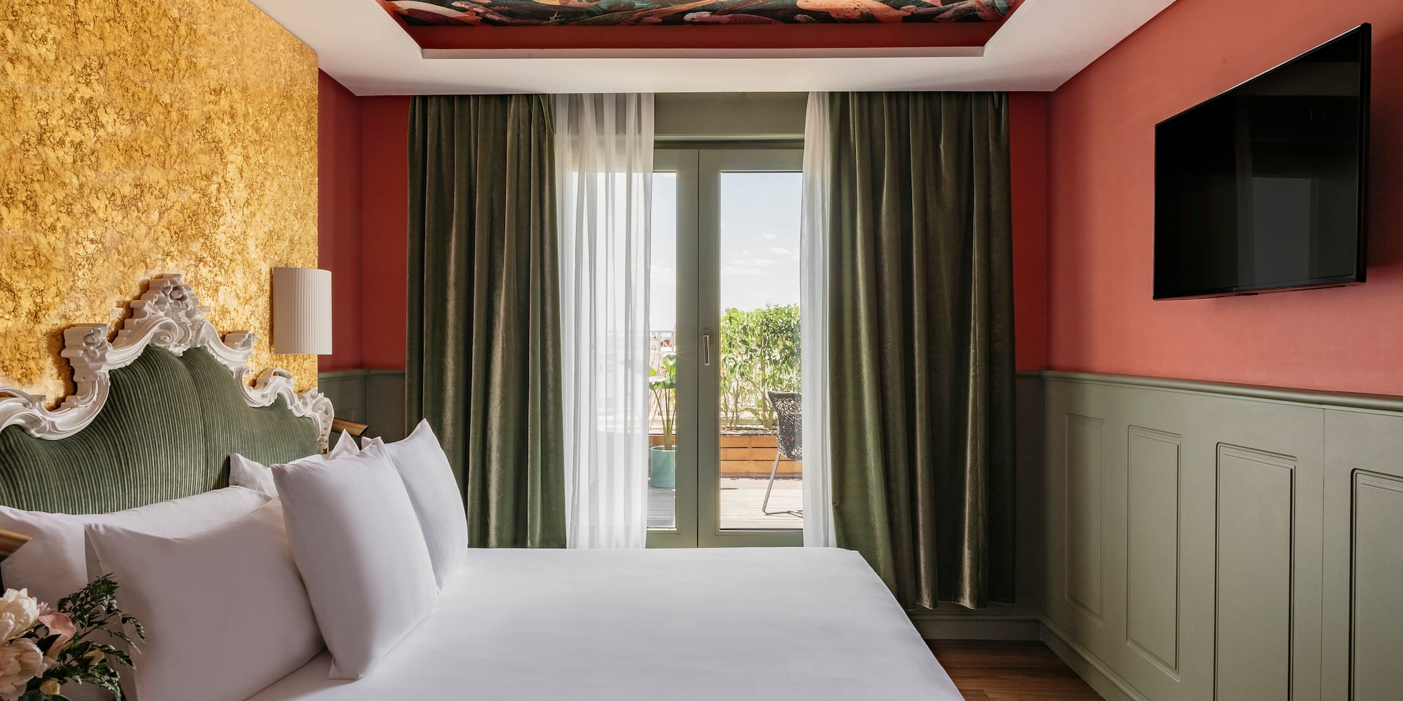 a bed in a room with a painting on the ceiling