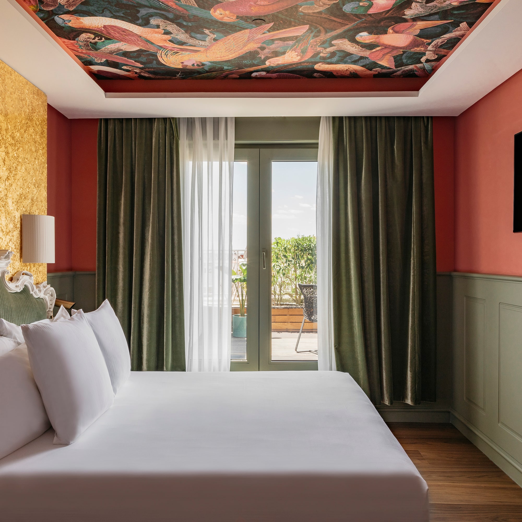 a bed in a room with a painting on the ceiling
